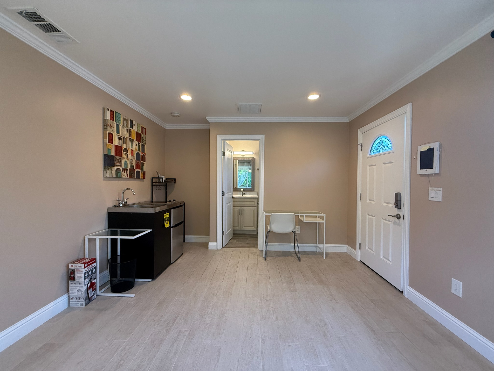 Studio with kitchenette, bathroom entrance, desk, and front door